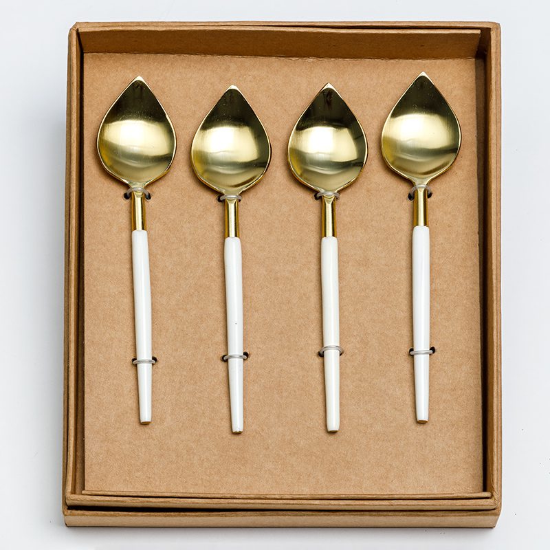 Gold white coffee spoons add a touch of style to a table setting.